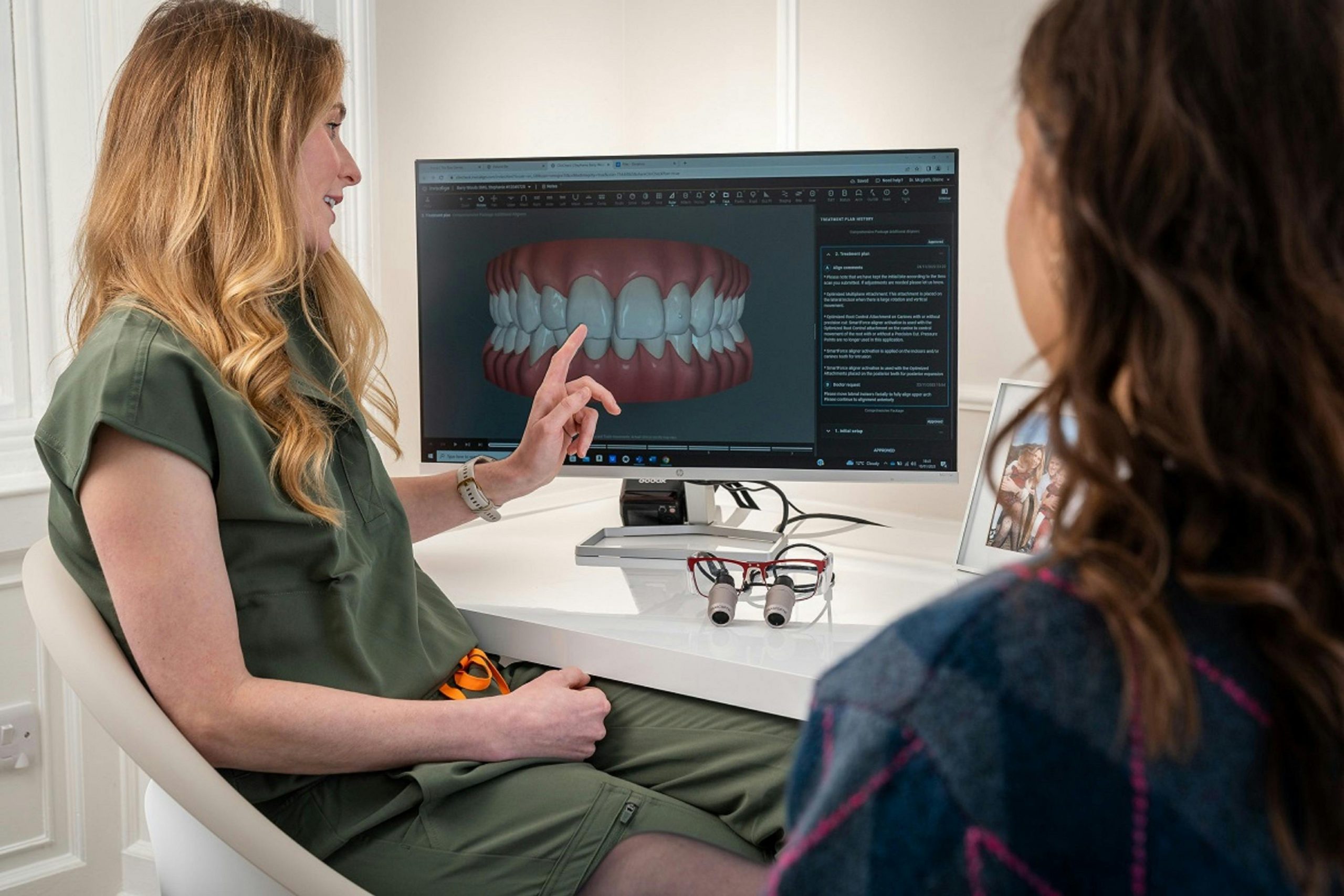 cosmetic dentist explaining a procedure to a patient, using a 3D model for illustration